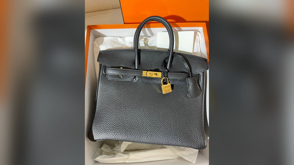 A pre-owned Hermès Birkin 25 in black Togo leather with gold hardware, in its orange box
