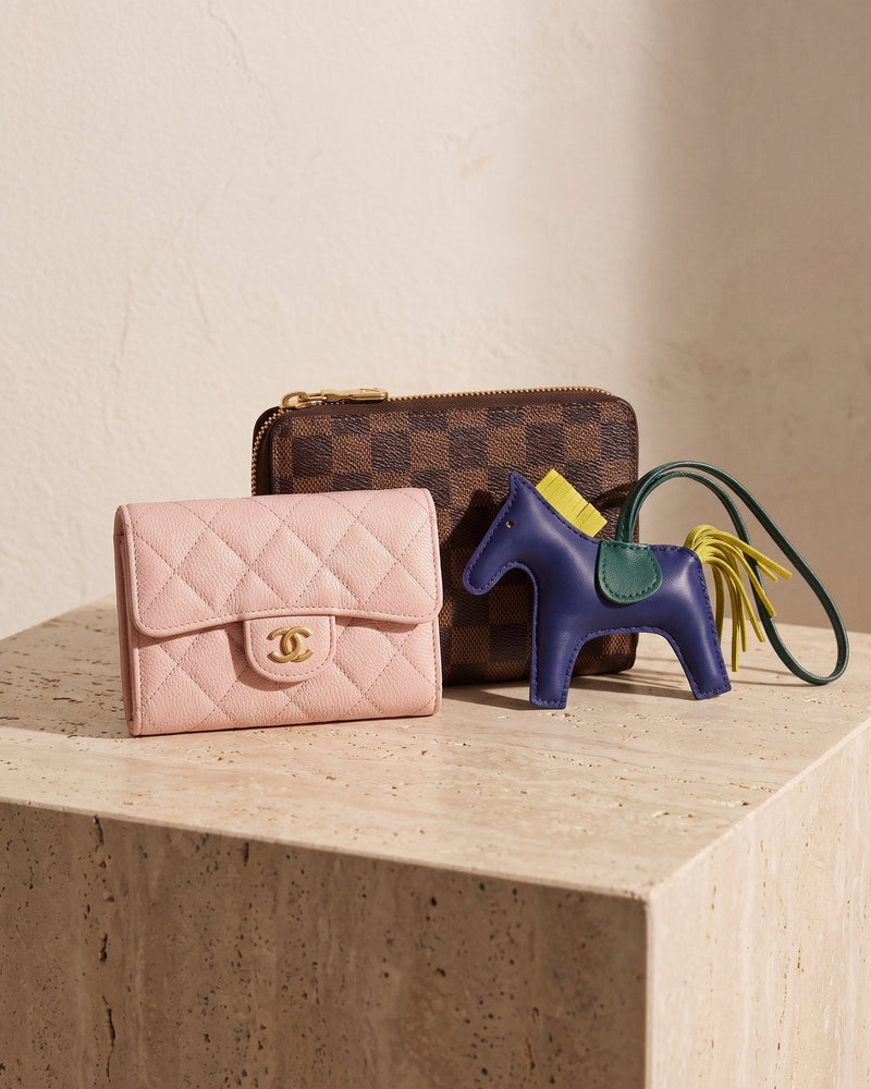 A pre-owned pink quilted Chanel card holder, a Louis Vuitton Damier zip wallet and a Hermès Rodeo bag charm at House of Brandz, Singapore